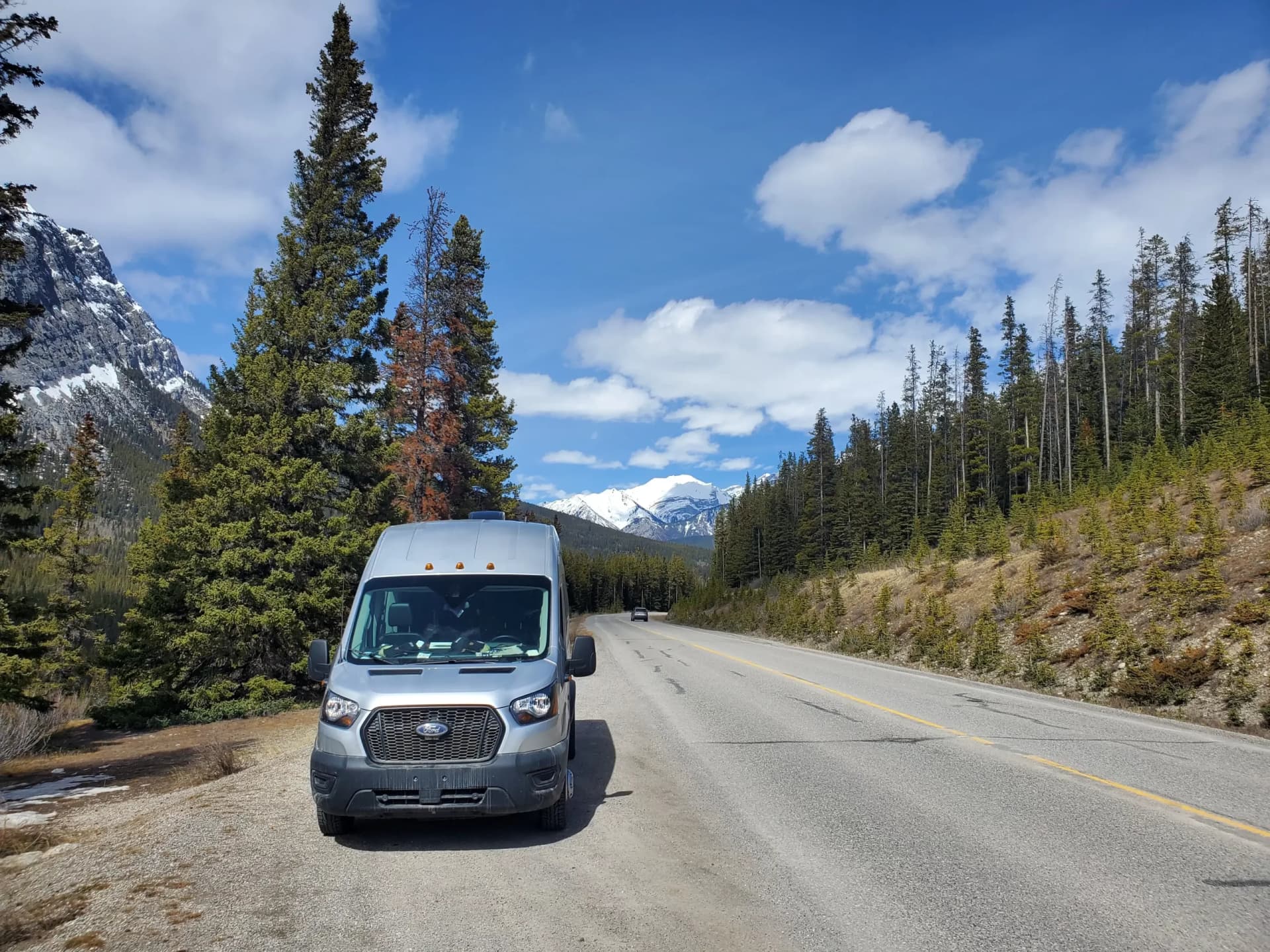 Reliable Campers Ford Transit high-roof on a mountain road in the Canadian Rockies